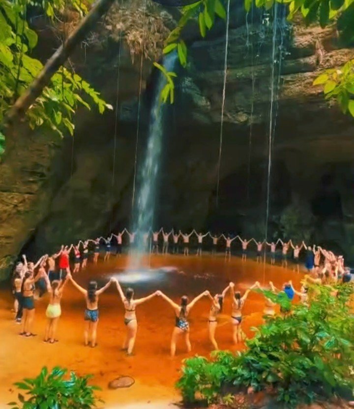 Grupo de mãos dadas em cachoeira de Presidente Figueiredo