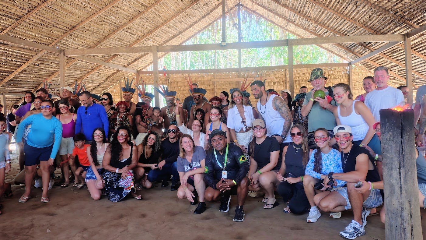 Grupo de turistas da Amazontur reunido em maloca amazônica